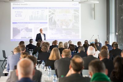 Photo of CEO Andreas Müller delivering his presentation with a projector to a crowded room of people sitting in rows