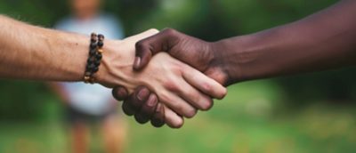 Two hands shaking hands, one white and one black by AI generated image.