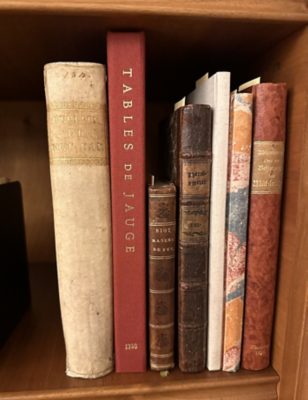 The parchment-bound volume on the shelf in the Iron Library.