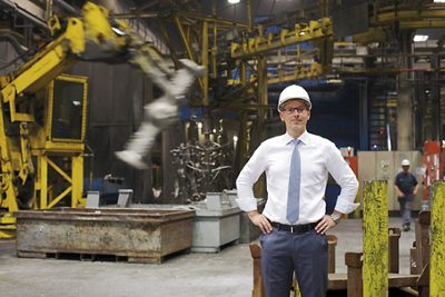 GF CS Employee standing in the production area looking at machinery