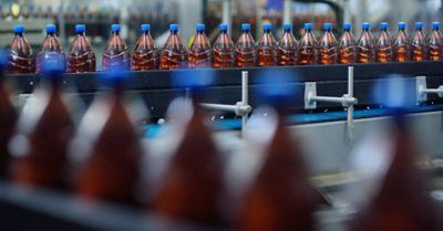 food industrial production of beer. Plastic beer bottles on a conveyor belt against the background of a brewery.