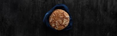 Freshly baked bread on black wooden background. Top view. Copy space.