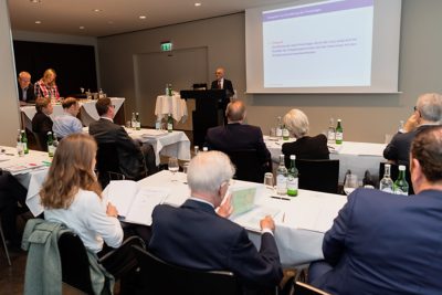 Professor Dr. Martin Hilb, President of SIoD, presenting the award in front of ceremony guests seated in rows of tables