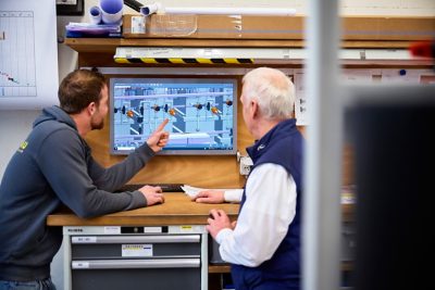 two men discussing, one of them pointing at a plan