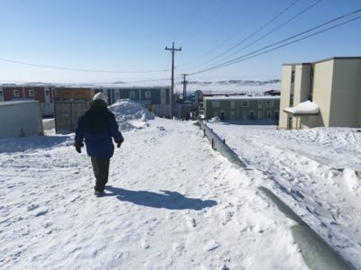 Man walking next to shallow bury pipe