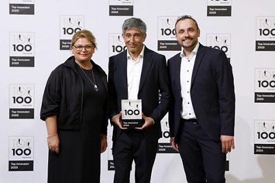 Happy about the TOP 100 seal hat trick and the congratulations from science journalist and mentor of TOP 100 Ranga Yogeshwar (center): Beatrix Pfundstein, Manager Global PR & Communications GF Building Flow Solutions and David Mainka, Senior Director, Heating and Cooling Solutions Development, GF Building Flow Solutions. Photo: Compamedia / IMPOSSIBLEFOTO