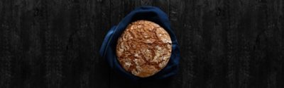 Freshly baked bread on black wooden background. Top view. Copy space.