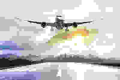 Passenger airplane taking off at sunset