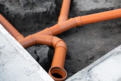 Prepared Drainage System from Plastic pipes made by plumber in the ground. Pre-building of a modular house in Europe. Deployment Internal Infrastructure, Engineering concept